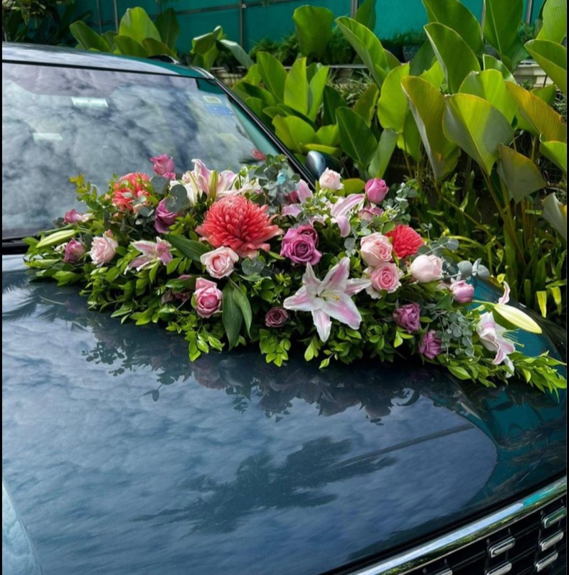 Torch ginger, lilies and roses on a teal wedding car